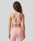 Back view of the FormLine Twist Sports Bra in pink, highlighting the cross-back design