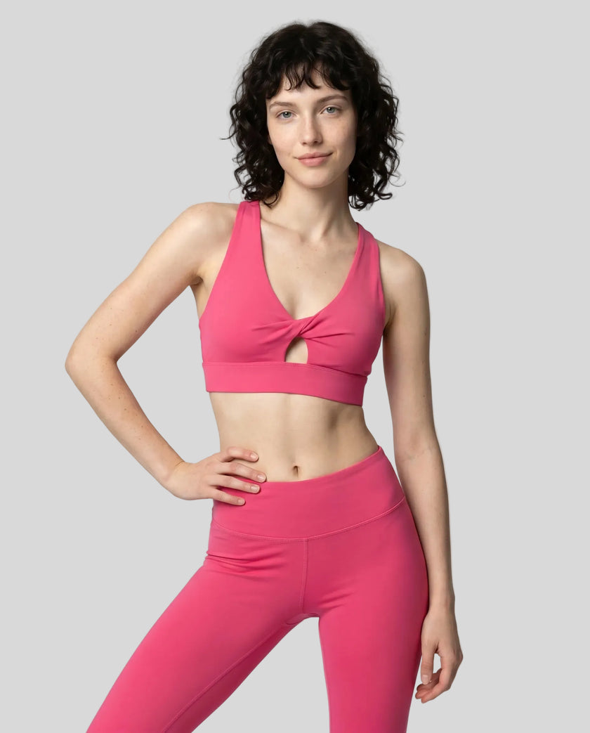 Model wearing the FormLine Twist Sports Bra in rose red front view