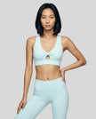 Model wearing the FormLine Twist Sports Bra in sky blue front view