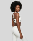 Angled back view of the FormLine Twist Sports Bra in shite, styled with coordinating activewear pieces