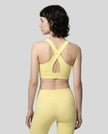 Back view of the FormLine Twist Sports Bra in yellow, highlighting the cross-back design