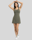 Woman wearing a green activewear dress on a gray background