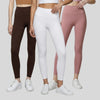 Three models wearing brown, white, and dusty pink leggings with white sneakers on a neutral setting