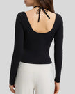 Back view showing open-back halter design with adjustable tie on Athlesi HaloContour top in black