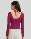 Back view showing open-back halter design with adjustable tie on Athlesi HaloContour top in hot pink