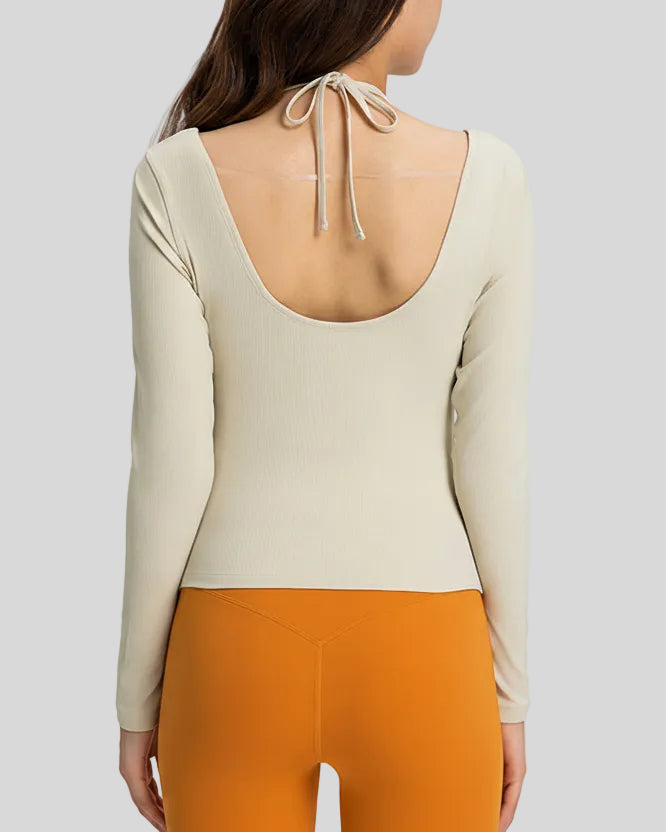 Back view showing open-back halter design with adjustable tie on Athlesi HaloContour top in ivory