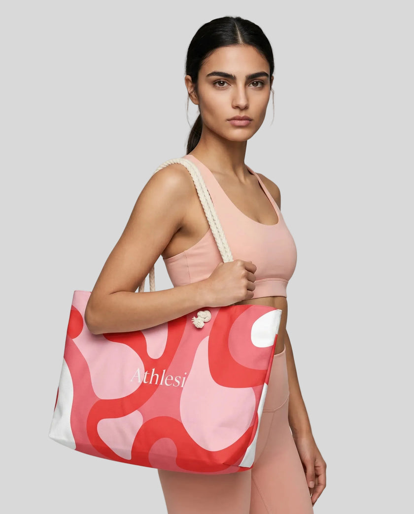 Model carrying oversized red swirl tote bag