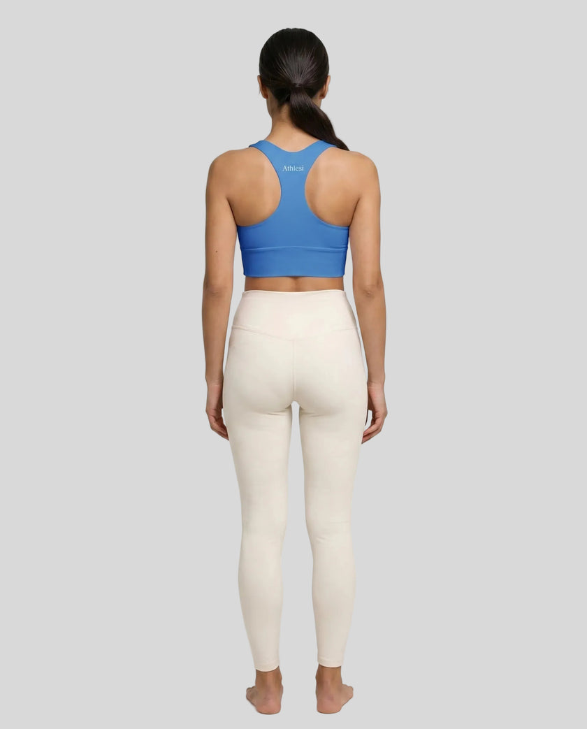 Athlesi model wearing cerulean blue sports bra back view