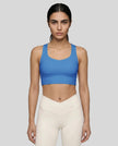Athlesi model wearing cerulean blue sports bra front view