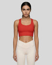 Athlesi model wearing tomato red sports bra front view