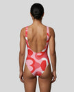 Model wearing red swirl swimsuit back view 