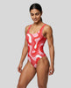 Model wearing red swirl swimsuit front left angle