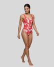 Model wearing red swirl swimsuit front left angle