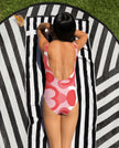 Red swirl swimsuit lying on towel back view