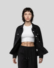 A model walks forward wearing a Heritage Denim Jacket in Black over a White tank top, Black Everyday Jogger Pants, and white sneakers.