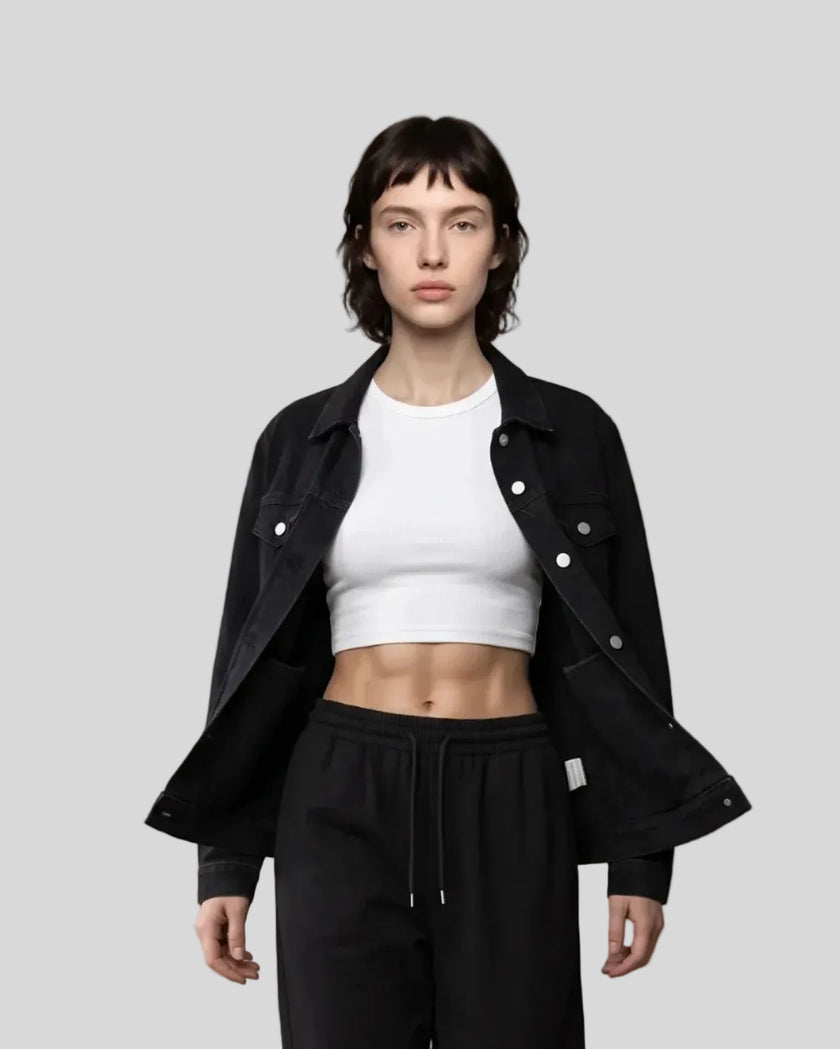 A model walks forward wearing a Heritage Denim Jacket in Black over a White tank top, Black Everyday Jogger Pants, and white sneakers.