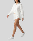 Side angled view of a model wearing the Heritage Lounge Shorts in White