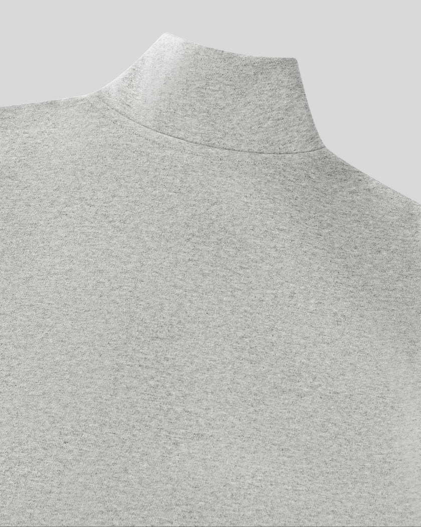 Close-up of a flower gray knit mock neck Athlesi Heritage Quarter-Zip Sweatshirt, showing the collar and textured fabric against a solid gray background.
