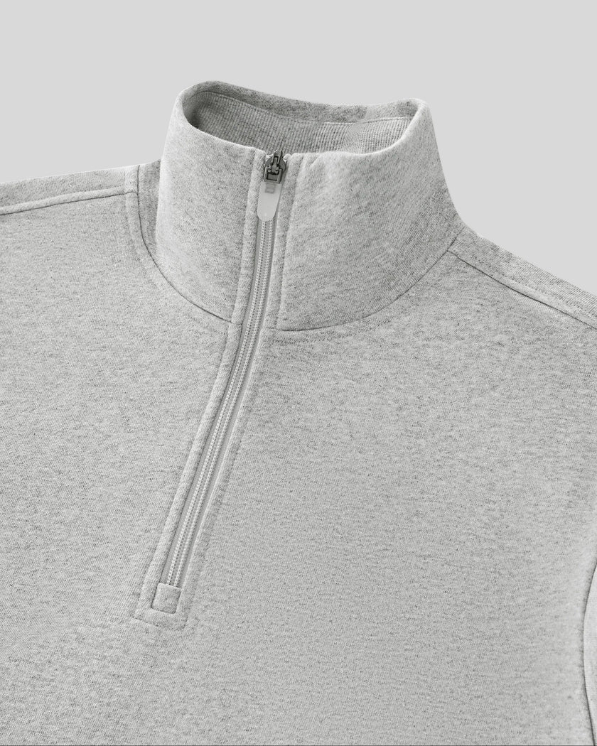 Close-up of flower gray Athlesi Heritage Quarter-Zip Sweatshirt with a high mock neck collar and a silver zipper pull, shown on a neutral gray background.