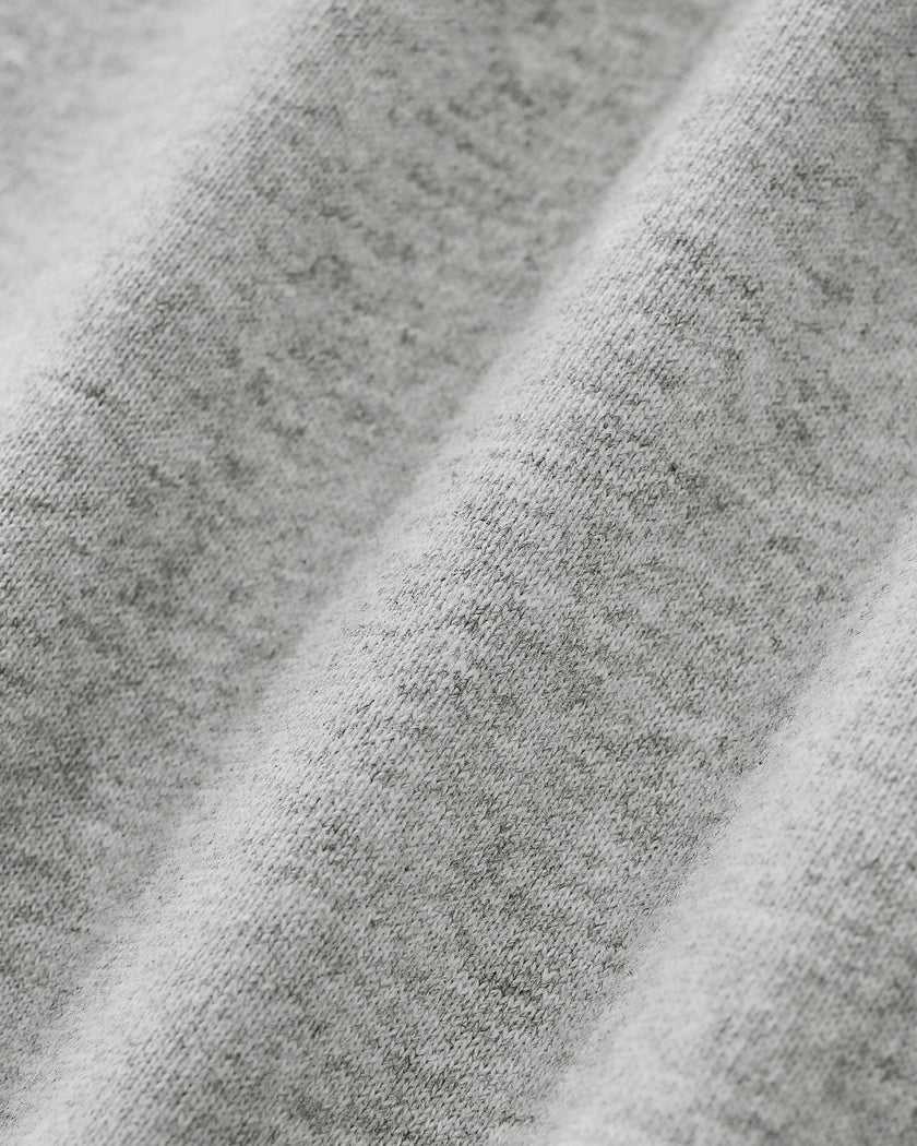 Close-up of Athlesi Heritage Quarter-Zip Sweatshirt in flower gray heathered fabric texture with soft diagonal folds.