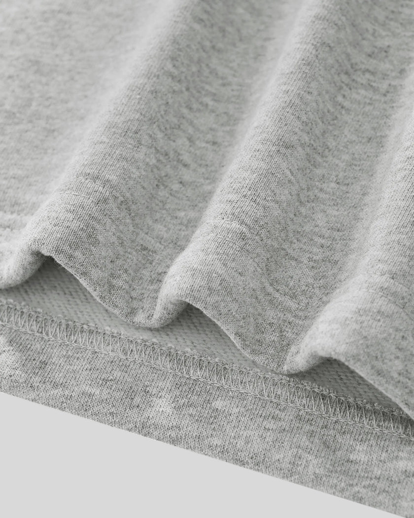 Close-up of Athlesi Heritage Quarter-Zip Sweatshirt in flower gray fabric with visible texture and hem stitching