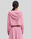 Back view of a model wearing the Heritage Washed Hoodie in Rose Pink