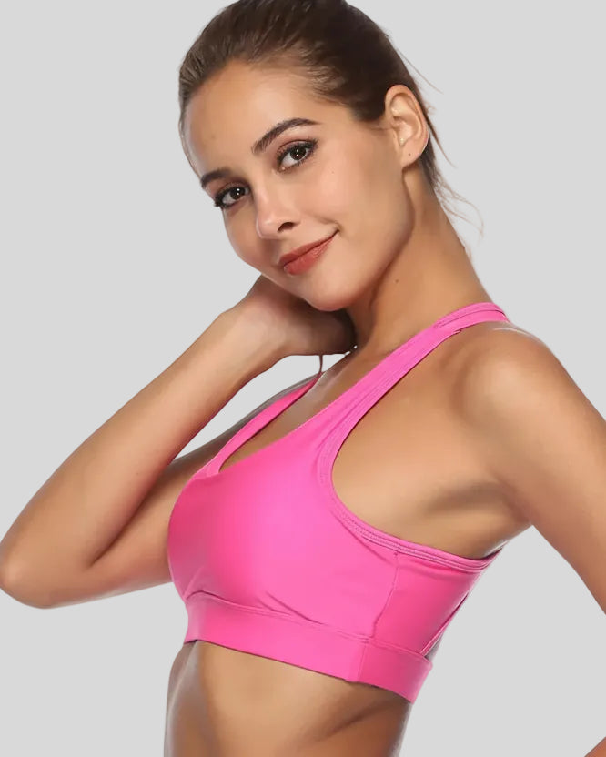 Sports bra with sculpted scoop neckline shown from left side angle in pink
