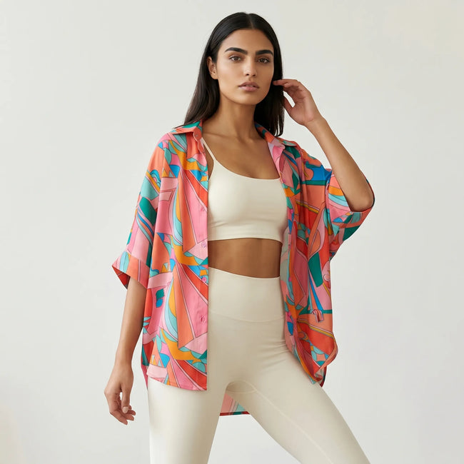 Woman wearing multicolor oversized printed shirt open over a white activewear outfit