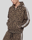 Upper body front angle view of woman wearing Leopard Accent Hoodie zipped closed in Leopard Coffee