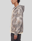 Upper body side view of man wearing oversized Leopard Vintage Accent Hoodie in Leopard Apricot