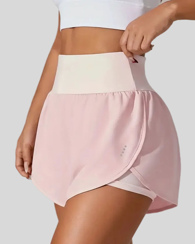 Front left angle of Athlesi LiftMove Pocket Active Shorts in blush pink showing flowy silhouette