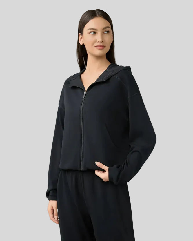 Black hoodie worn half-zipped, styled for layering.