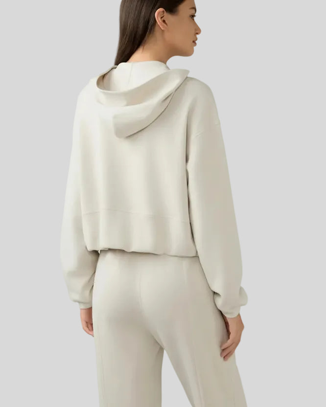 Back view of cream zip-up hoodie with hood and relaxed drape