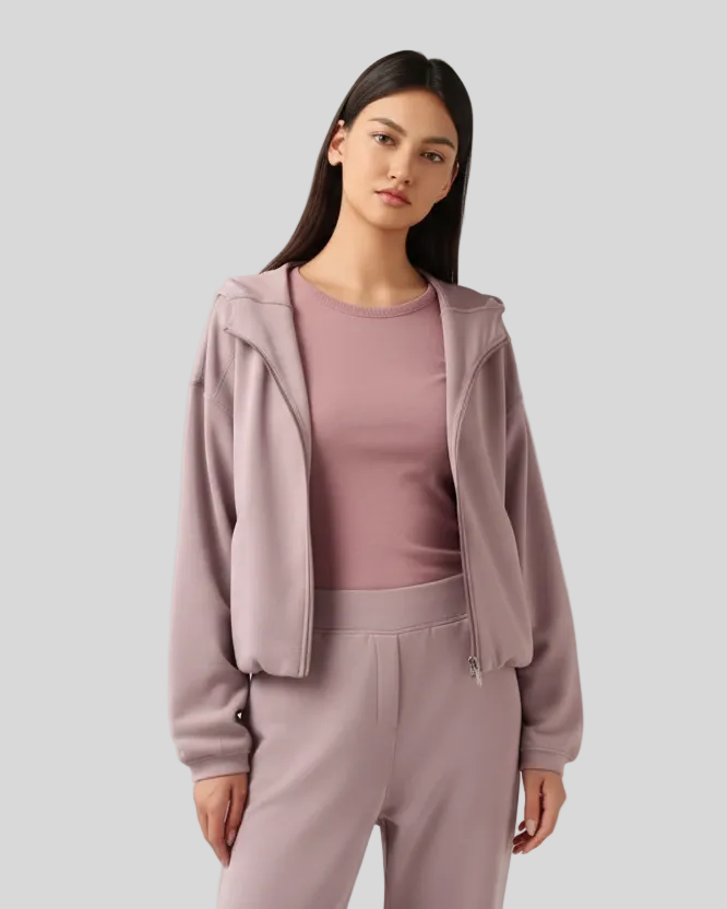 Woman wearing a light pink outfit on a plain background