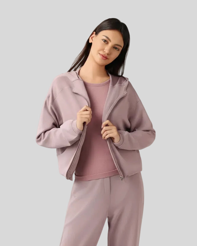 Dusty pink hoodie worn half-zipped, styled for layering.