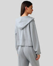 Back view of light blue zip-up hoodie with hood and relaxed drape