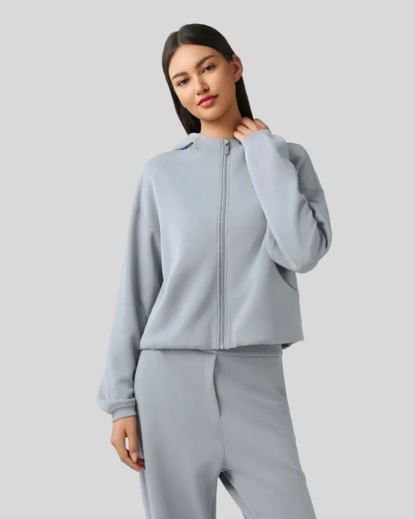 Angled front view showing dropped shoulders and clean zip-up design in Light Blue