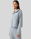 Light blue hoodie worn half-zipped, styled for layering.