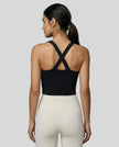Back view of model wearing a black LumaForm Cross-Neck Cami highlighting crisscross back