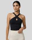 Front view of model wearing a black LumaForm Cross-Neck Cami highlighting silhouette and neck design