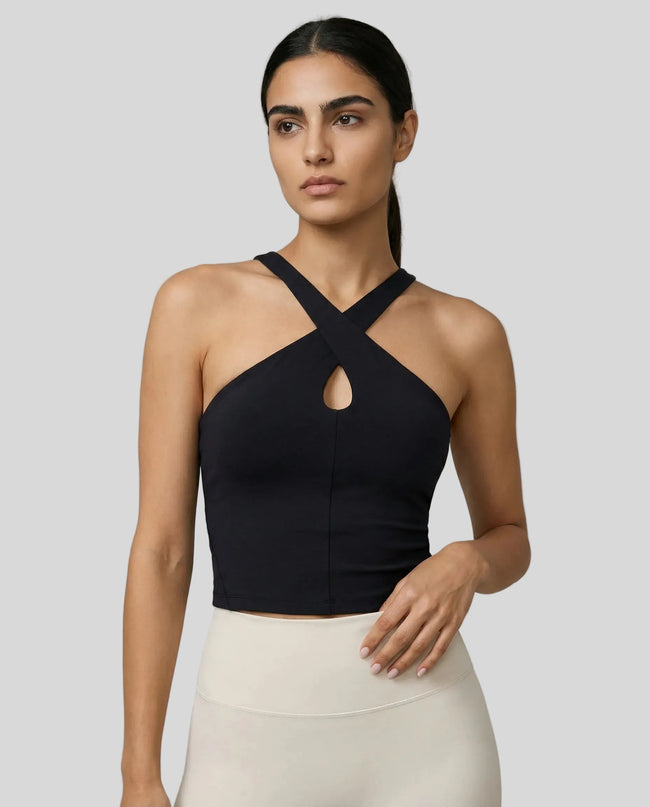 Front view of model wearing a black LumaForm Cross-Neck Cami highlighting silhouette and neck design