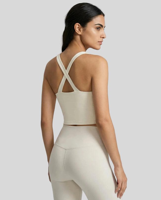 Back view of model wearing a cream LumaForm Cross-Neck Cami highlighting crisscross back