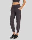 Angled front view of MotionEase Sculpt Jogger Pant in dark gray, showing tapered leg