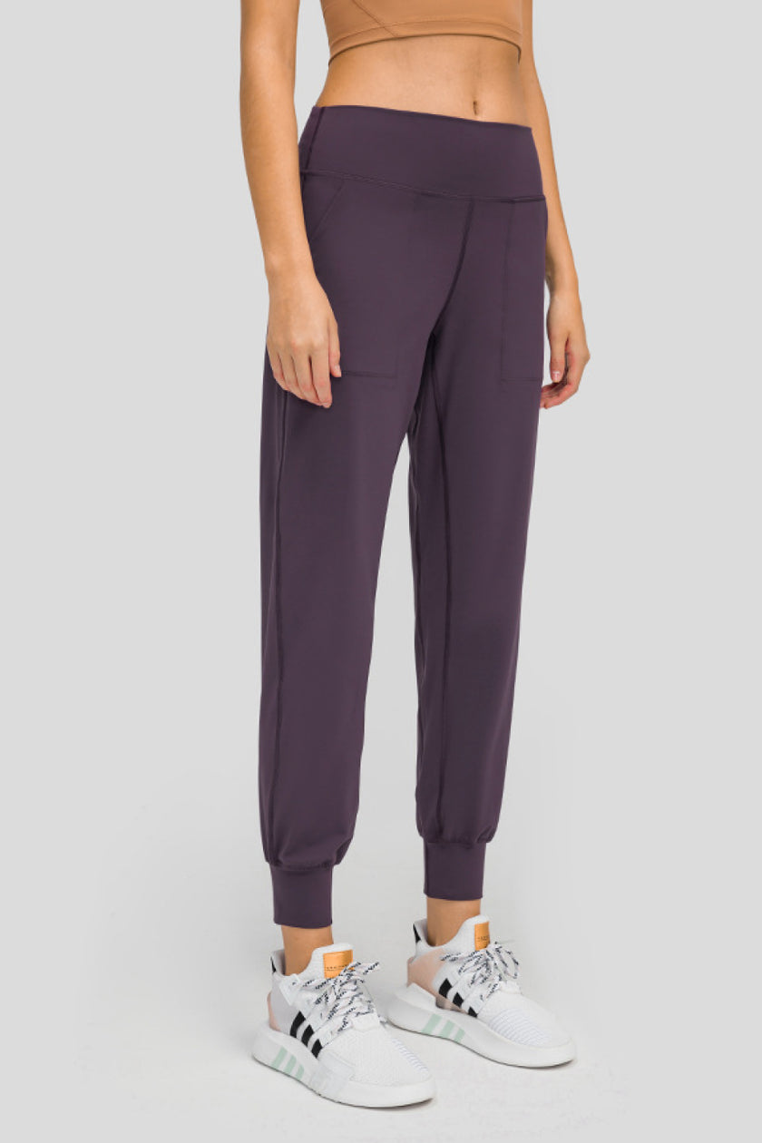 Angled front view of MotionEase Sculpt Jogger Pant in plum purple, showing tapered leg
