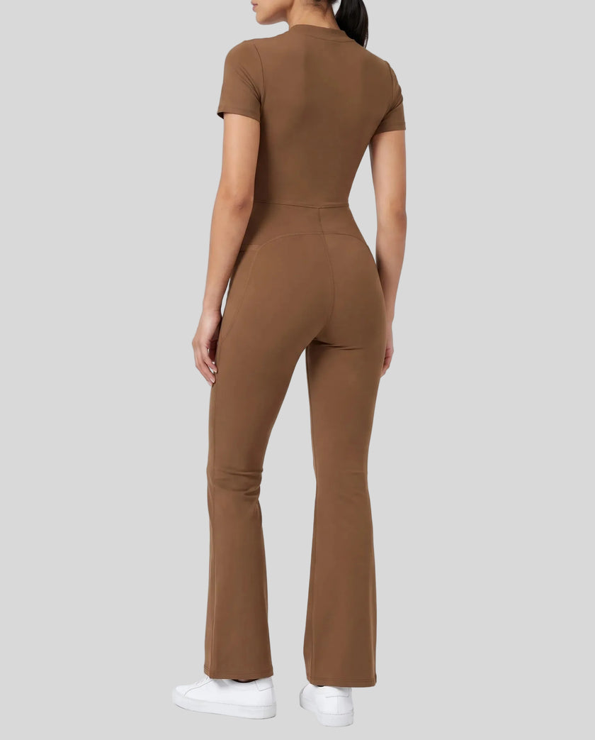 Back angled view of a model wearing the MotionFlow Flared Leg Jumpsuit in Brown