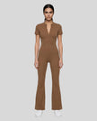 Model wearing the MotionFlow Flared Leg Jumpsuit in Brown viewed from the front