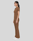 Side view of a model wearing the MotionFlow Flared Leg Jumpsuit in Brown
