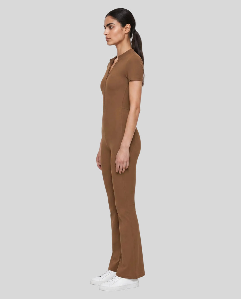 Side view of a model wearing the MotionFlow Flared Leg Jumpsuit in Brown
