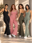 Four women wearing the MotionFlow Halter Jumpsuit in Black, Pink, Army Green and Gray Green viewed from the front
