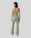Back view of a model wearing the MotionFlow Halter Jumpsuit in Gray Green